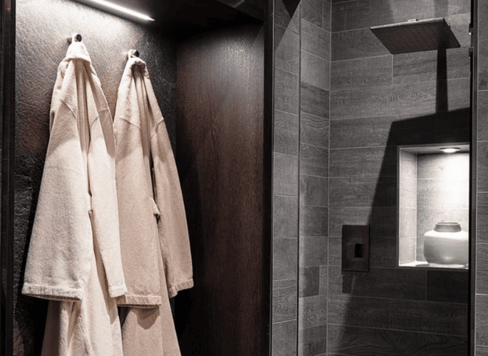 Two-luxury-dressing-gowns-hanging-in-a-home-spa-by-Glancy-Fawcett-luxury-interior-outfitter.