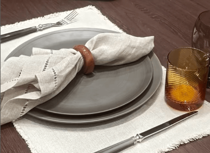 a rustic and organic tablescape with linen napkins and wooden napkin rings